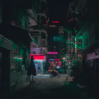 Motorcycle riding down a narrow neon lit street at night